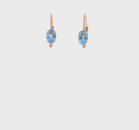 Pendientes de Oro Amarillo de 14k con Topacio Azul Suizo Ovalado de 6x4mm y Cierre LeverBack